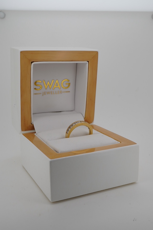 A diamond half hoop ring, channel-set to the front with princess-cut diamonds totalling approximately 0.60 carats, mounted in 18ct gold, size L, British hallmarks, gross weight approximately 4 grams